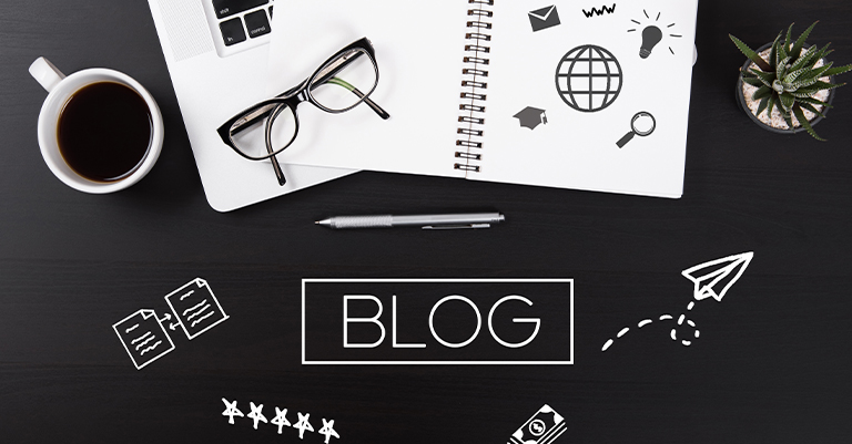 GuestBlog_2 • Andrew Roche SEO A flat lay of a blogger’s workspace features a notebook with icons, a cup of coffee, eyeglasses, a laptop corner, and a succulent plant on a dark desk.