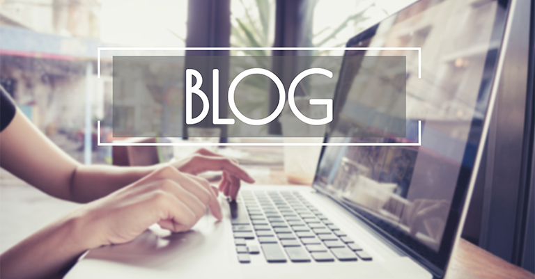 GuestBlog_3 • Andrew Roche SEO Hands typing on a laptop near a window with the word “BLOG” overlaid in bold text, symbolizing content creation in a relaxed work environment.