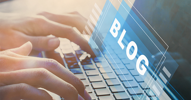 GuestBlog_4 • Andrew Roche SEO Fingers typing on a laptop keyboard with a translucent digital overlay that says “BLOG,” capturing the energy of online publishing and content creation.
